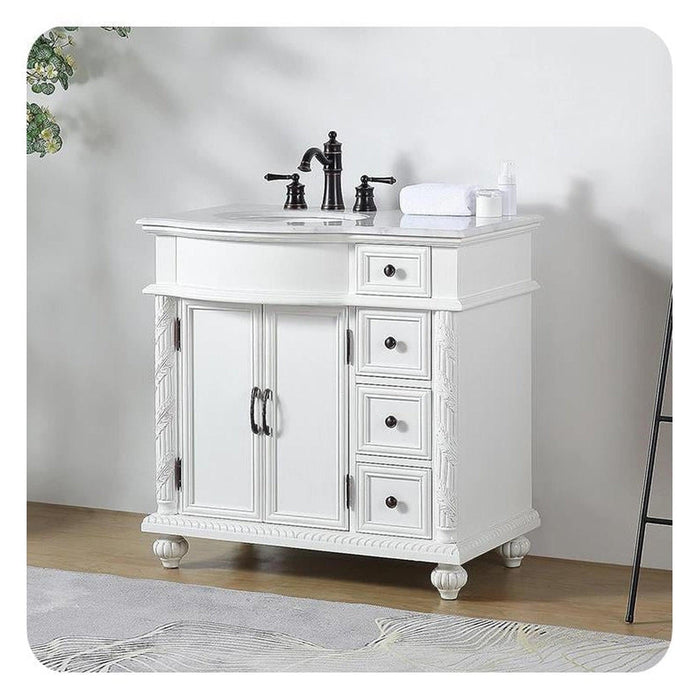 White bathroom vanity with black faucet, three drawers, double cabinet doors, and decorative turned legs.