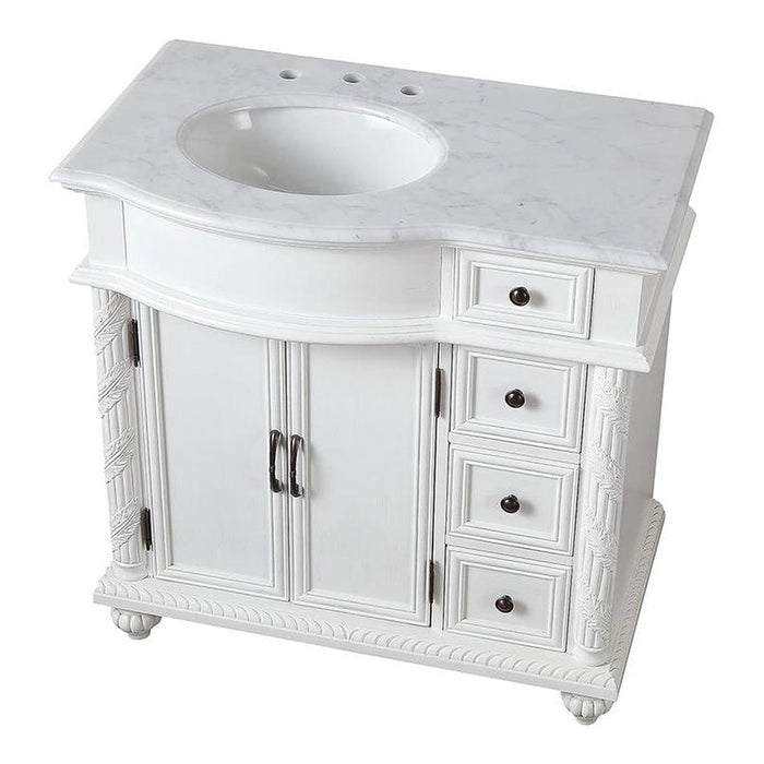 White bathroom vanity with marble top, two cabinet doors, and four drawers with decorative carved details and round sink