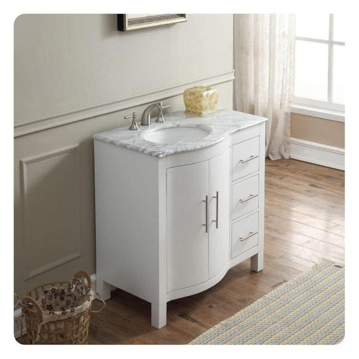 White bathroom vanity with marble top, curved design, and three-drawer storage next to a window