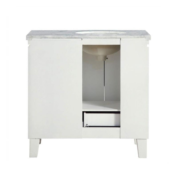 White bathroom vanity with marble top, open door revealing interior shelf and storage space.