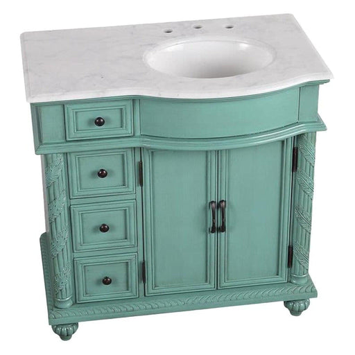Vintage-style teal bathroom vanity with white marble top, three drawers, and double cabinet doors with ornate details.