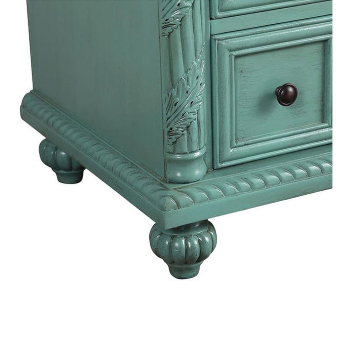 Vintage sage green wooden drawer with ornate carved details, dark round knob, and decorative bun feet.