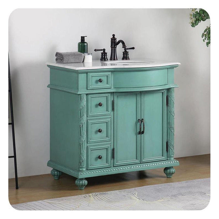 Vintage-style teal bathroom vanity with white marble top, black faucet, and decorative carved details on legs and sides.