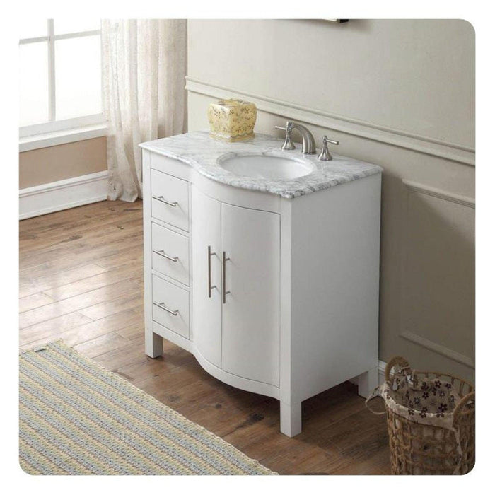 White bathroom vanity with marble top, curved design, three drawers, and chrome faucet against wooden floor and white walls.