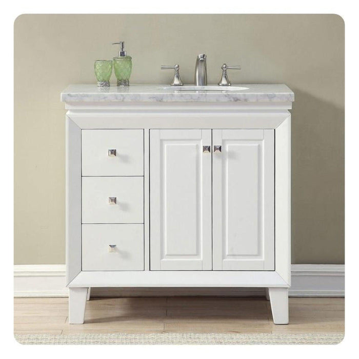 White bathroom vanity with marble top, three drawers, two cabinet doors, and green soap dispensers on a light neutral background.