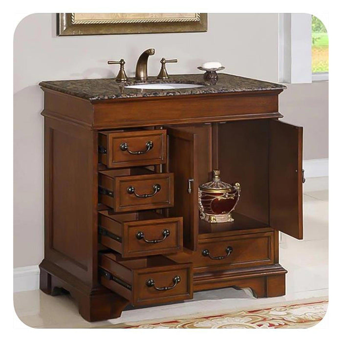 Classic wooden bathroom vanity with marble top, bronze fixtures, and multiple drawers open to reveal interior storage.