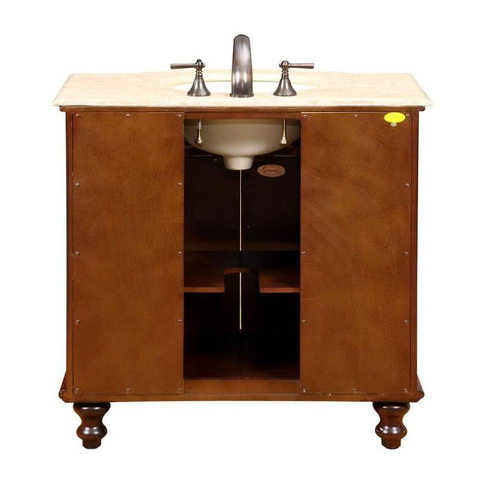Wooden bathroom vanity with marble top, white sink, and brushed nickel faucet and hardware, featuring turned legs and open storage compartment.