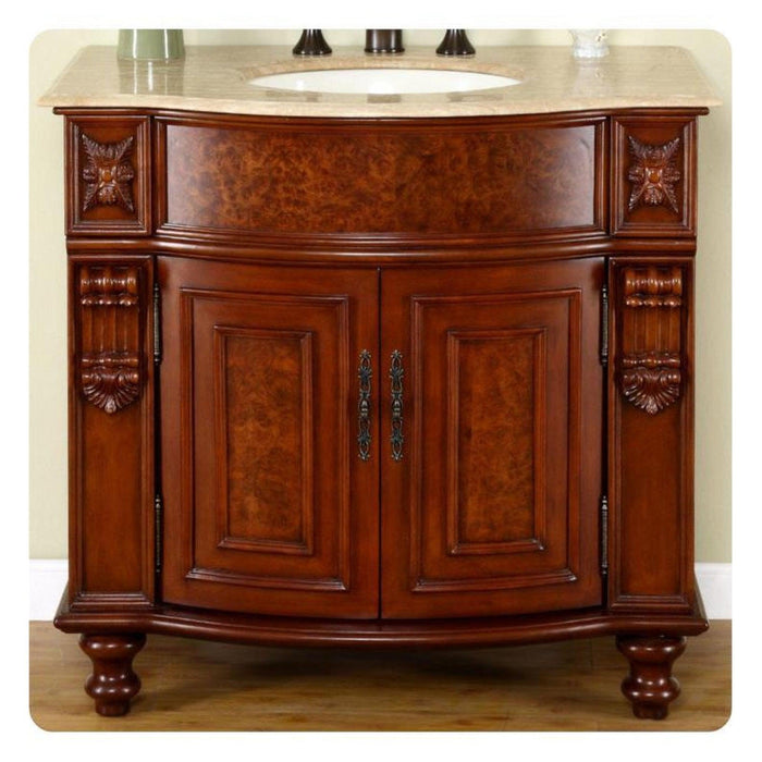 Elegant wooden bathroom vanity with curved doors, ornate carved details, and a marble top with oval sink.