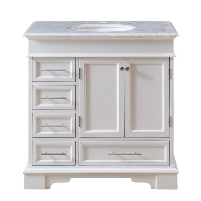 White bathroom vanity with marble top, four drawers, and two cabinet doors with oval undermount sink.