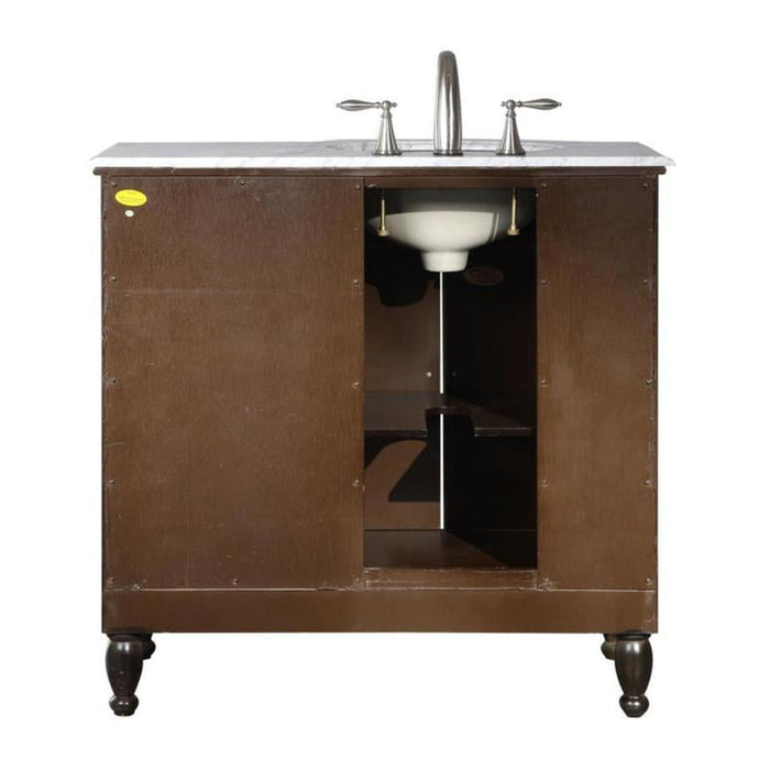 Dark wood bathroom vanity with white marble top, open cabinet revealing sink and shelving, brushed nickel faucet and handles.