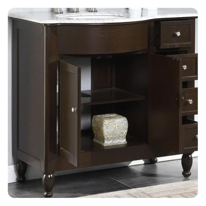 Dark wood bathroom vanity with marble top, open cabinet door revealing decorative ceramic container on lower shelf