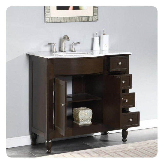 Dark wooden bathroom vanity with white marble top, silver faucet, and four side drawers, with decorative ceramic object on lower shelf.