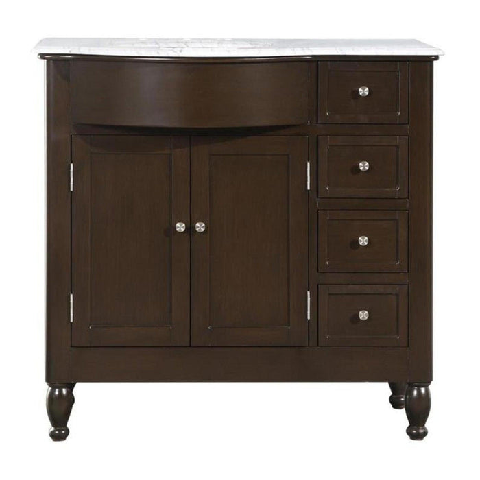 Dark wood bathroom vanity with white marble top, two cabinet doors, and four drawers with round silver knobs, standing on turned legs.
