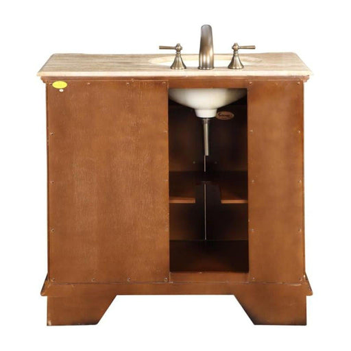 Wooden bathroom vanity with marble top, undermount sink, and brushed nickel faucet; open shelving inside brown cabinet.