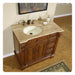 Wooden bathroom vanity with travertine countertop, white sink, bronze faucet, and decorative carved details on rich brown cabinetry.