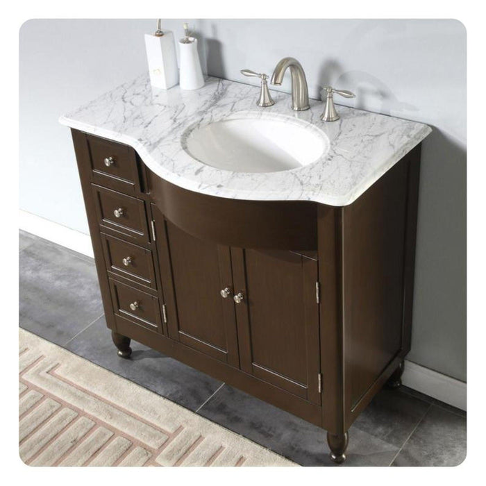Dark brown bathroom vanity with marble top, undermount sink, and brushed nickel faucet.