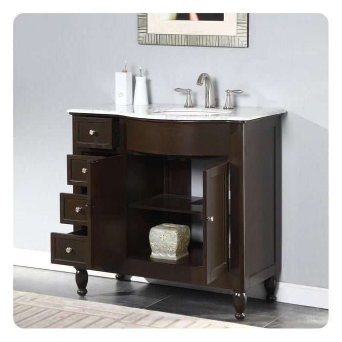 Dark wood bathroom vanity with white marble top, brushed nickel faucet, and open shelving with decorative accent.
