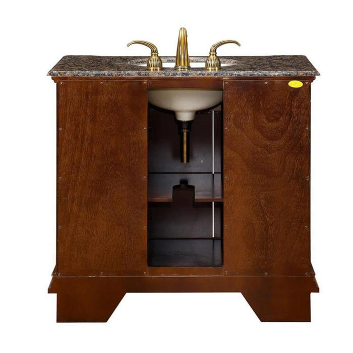 Wooden bathroom vanity with marble top, gold-toned fixtures, and open storage shelves underneath the sink.