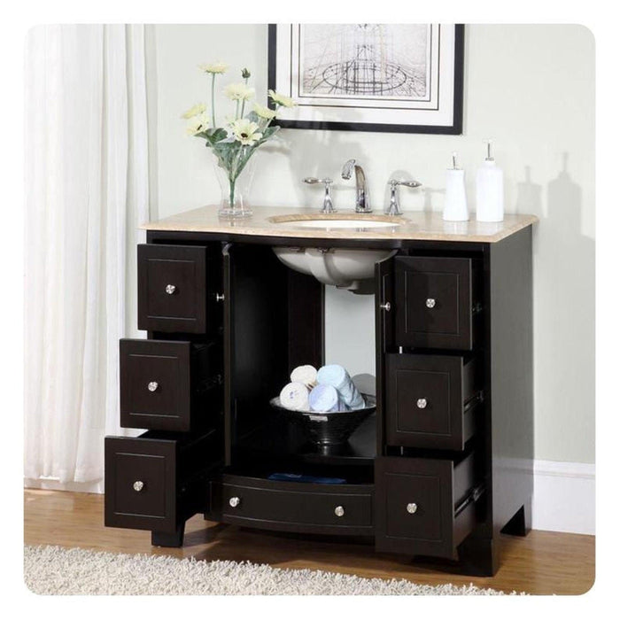 Black bathroom vanity with six drawers, marble top, undermount sink, and white flowers in a vase above.