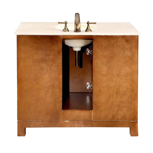 Wooden bathroom vanity with white marble top, bronze faucet, and open cabinet doors revealing interior storage space.
