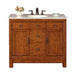 Wooden bathroom vanity with white marble top, bronze faucet, three drawers, two cabinets, and a small vase of roses.