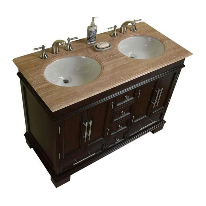 Dark wood bathroom vanity with travertine top, two white sinks, and chrome faucets and soap dispenser.