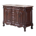 Ornate wooden bathroom vanity with carved details, curved legs, and white marble top featuring two undermount sinks.