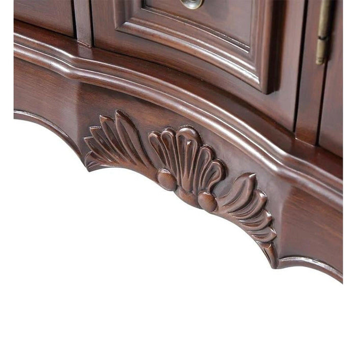 Ornate wooden furniture detail with carved shell-like motif on dark brown curved surface, showing intricate woodworking craftsmanship.