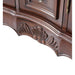 Ornate wooden furniture detail with carved shell-like motif on dark brown curved surface, showing intricate woodworking craftsmanship.