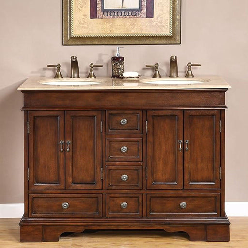 Traditional wooden bathroom vanity with dark brown finish, double sinks, marble countertop, and decorative bronze faucets and hardware.