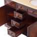 Rich mahogany vanity with multiple open drawers showing dark wood grain and antique brass drawer pulls