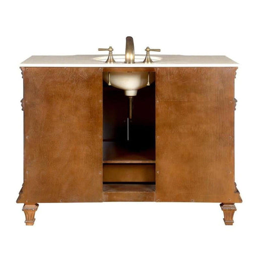 Wooden bathroom vanity with white marble top, bronze faucet, and decorative carved legs, featuring open storage beneath the sink.