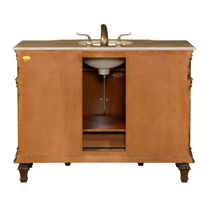 Wooden bathroom vanity with bronze faucet and marble countertop, featuring carved legs and central cabinet storage.