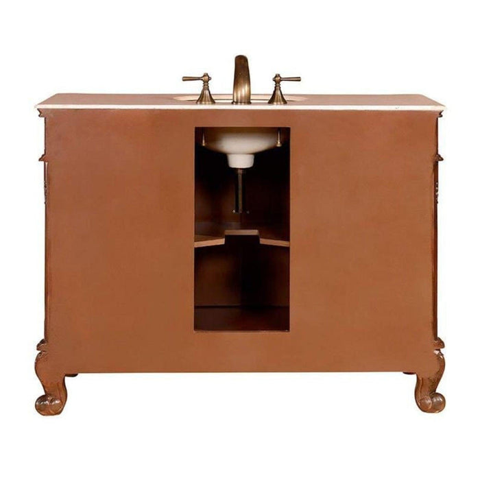 Vintage-style bathroom vanity in warm brown with curved legs and white marble countertop, featuring a centered sink and ornate faucet handles.