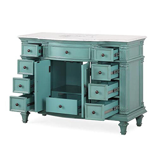 Vintage teal wood desk with multiple open drawers and ornate carved details, white marble top, decorative hardware.