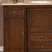 Rich wood bathroom vanity with raised panel cabinet door, ornate drawer pulls, and marble countertop.