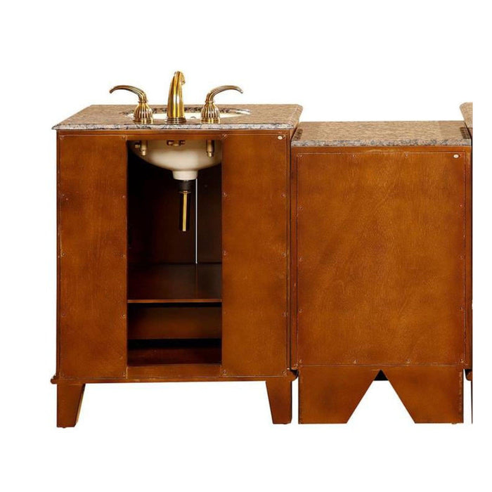 Wood bathroom vanity with marble top, gold faucet, and open cabinet doors revealing interior storage shelf.