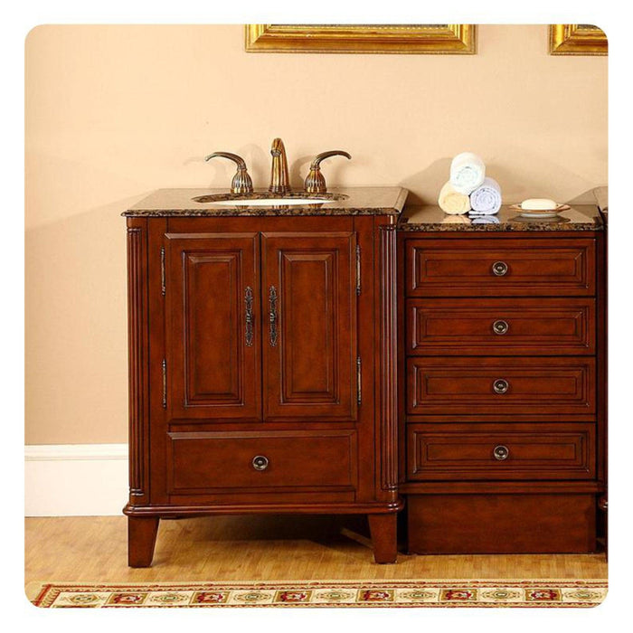 Cherry wood bathroom vanity with marble top, sink, and decorative drawers, with rolled towels and soap dish nearby.
