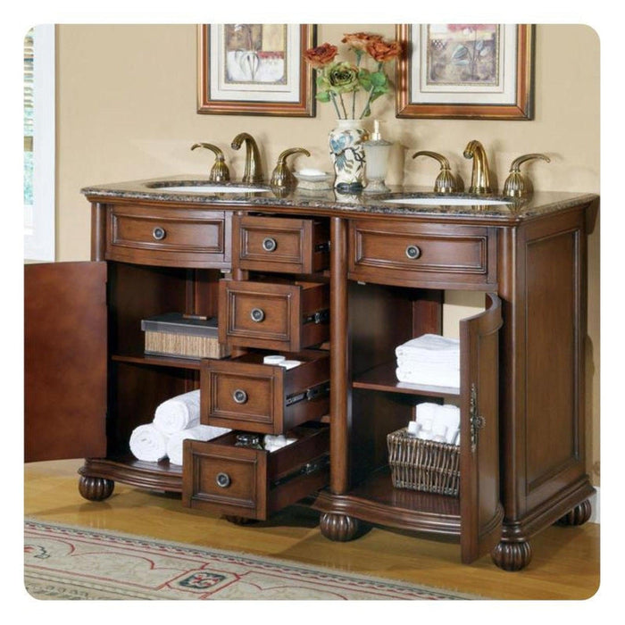 Elegant wooden bathroom vanity with marble top, multiple drawers, brass faucets, and white towels neatly stacked on shelves.