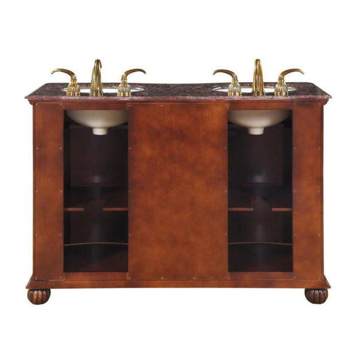 Rich wood bathroom vanity with marble top, two sinks, and gold fixtures, featuring open shelving and decorative bun feet.