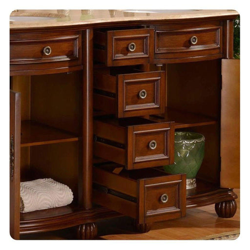 Rich mahogany bathroom vanity with multiple drawers, decorative round pulls, open shelving, and a white towel and green ceramic accent piece.