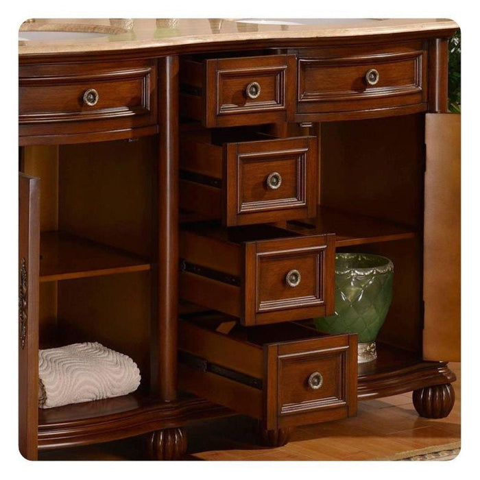 Rich mahogany bathroom vanity with multiple drawers, decorative round pulls, open shelving, and a white towel and green ceramic accent piece.