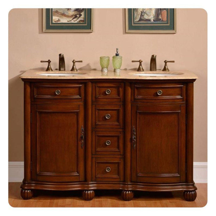 Rich wood double vanity with marble top, two sinks, bronze fixtures, and decorative green accessories between framed artwork.