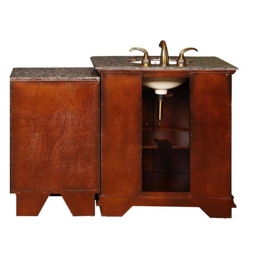 Cherry wood bathroom vanity with granite countertop, white sink, and brass faucet handles, featuring open storage compartment and side cabinet.