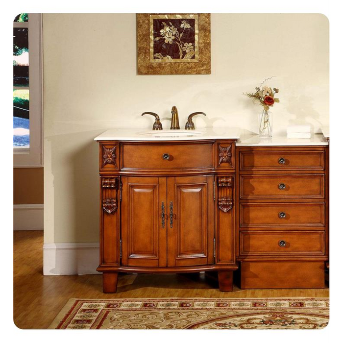 Elegant wooden bathroom vanity with curved cabinet, white marble top, and decorative floral artwork hanging above.