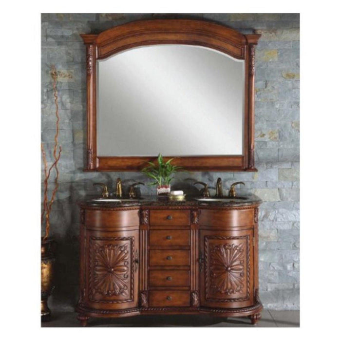 Ornate wooden bathroom vanity with curved design, double sinks, granite top, and matching arched mirror on stone wall with small plant.
