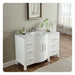 White bathroom vanity with marble top, curved design, drawers, and houseplant by sheer curtained window