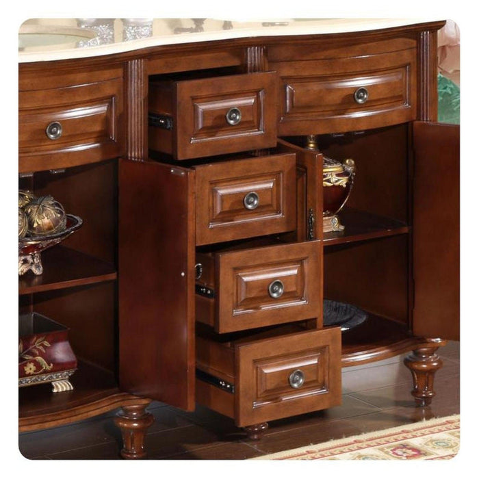 Polished wooden furniture with multiple open drawers, ornate hardware, and decorative turned legs on a patterned floor.