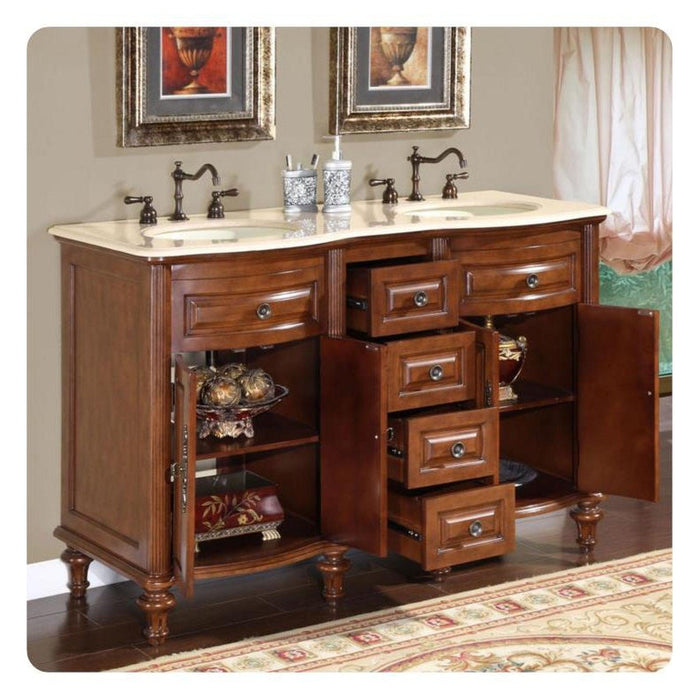 Classic wooden bathroom vanity with double sinks, marble top, ornate faucets, and open drawers revealing decorative shelving and accessories.