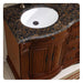 Ornate wooden bathroom vanity with curved Baltic brown granite countertop and white undermount sink